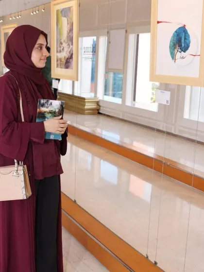 A visitor thoughtfully observing an artwork at the 'Ethereal Charm' show.
