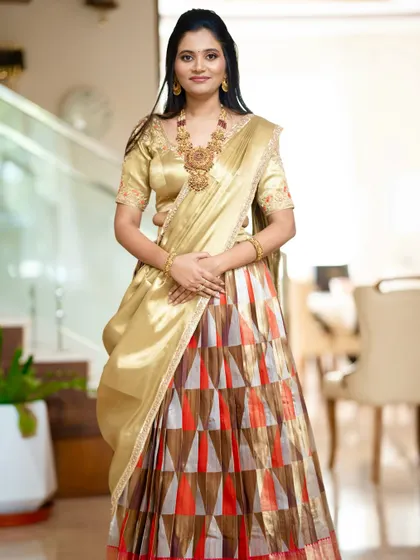 A client looking elegant in a custom Kanchipuram half saree with a geometric pattern and a golden embroidered blouse.
