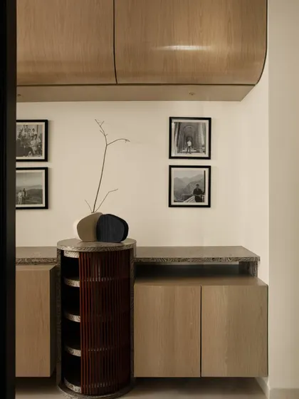 This multipurpose room is designed for both work and relaxation. The custom console and shelving are crafted from bold wooden veneer, creating a cozy and inviting atmosphere.