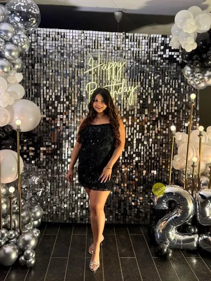 A glamorous 25th birthday celebration. The silver sequin wall, paired with a black, white, and silver balloon arrangement and foil number balloons, created a chic and sparkling photo corner.