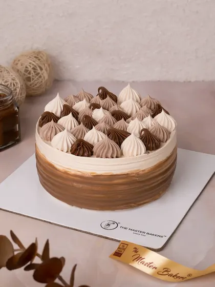 Our Choco Caramel Cake is a symphony of sweet and rich flavors. We decorate it with beautiful two-toned swirls of chocolate and caramel frosting, creating a simple yet elegant look.