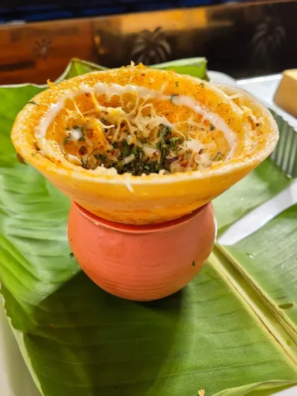 A creative take on a South Indian classic. This dish, served in a crispy dosa cup, is filled with a cheesy, herbed mixture, showcasing our flair for fusion cuisine.