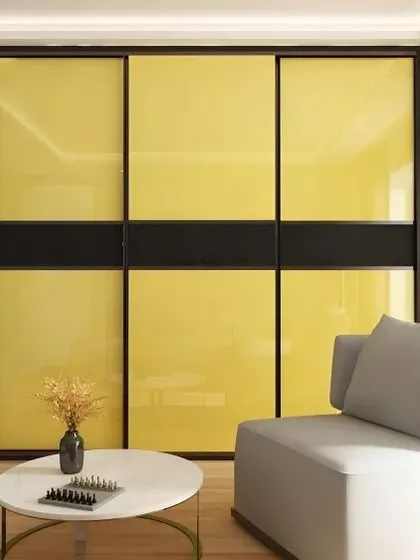 A modern sliding wardrobe with vibrant yellow lacquered glass panels, framed in black. This piece adds a bold pop of color and contemporary style to the bedroom.