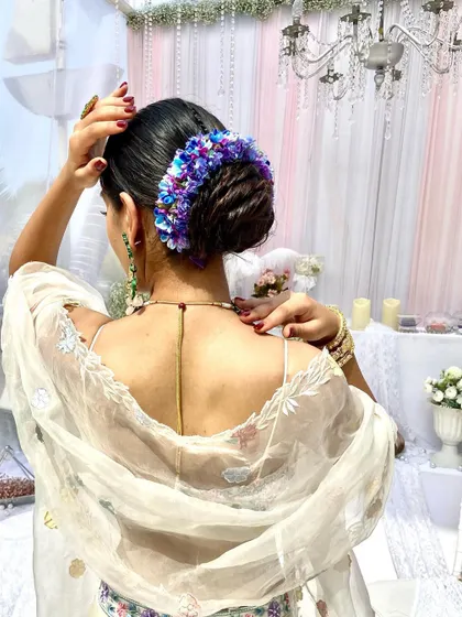 A stunning bridal bun adorned with a mix of blue and purple hydrangeas. This is a great way to add a pop of unexpected color to your bridal look.