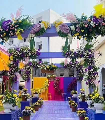 A stunning floral archway for a Haldi ceremony, decorated with an abundance of purple and yellow flowers. This creates a grand and colorful entrance for guests.