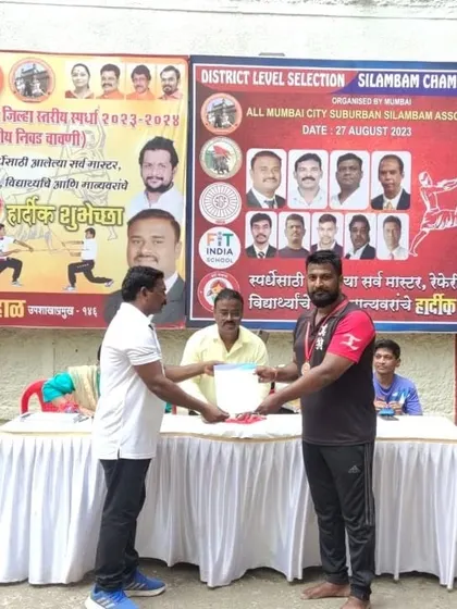 A student proudly receiving his medal at the Silambam championship. These events build confidence and character.