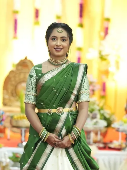 A full-length view of this beautiful engagement look. The makeup is balanced to complement her traditional half-saree, creating a cohesive and elegant style.