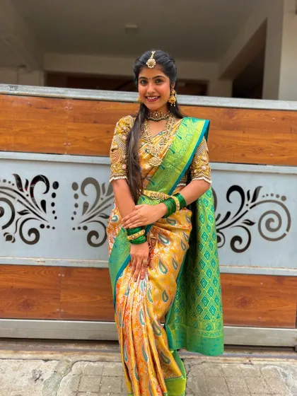 A full-length view of this gorgeous yellow and green Kanchipuram silk saree. The paisley motifs and the grand border make it a classic choice for weddings and festive events.