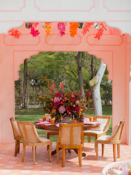 A dining table set within a pink archway at the 'Gulbahar' event. The design focused on creating intimate, beautiful spaces for guests to enjoy within the larger celebration.