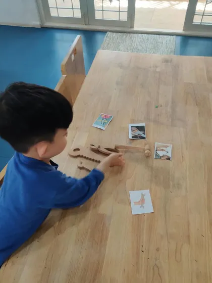 Another child thoughtfully works on the tool-matching activity. I provide various independent tasks to accommodate different learning paces.