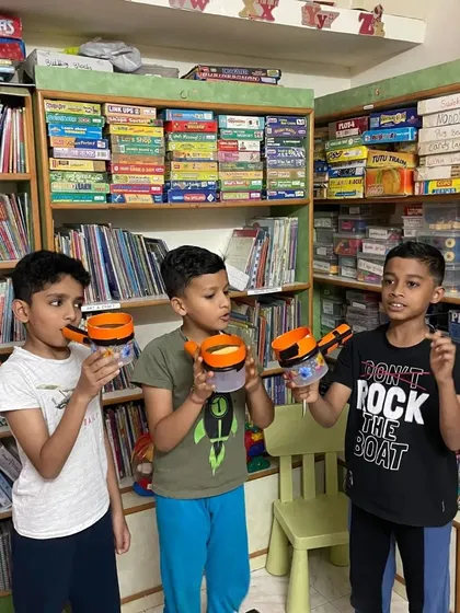 Three boys proudly show off the string telephones they built to learn about sound vibrations.
