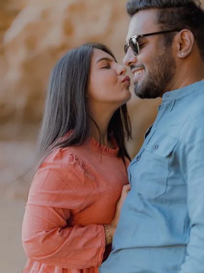 A sweet and playful moment with a gentle kiss on the cheek, capturing the couple's affection.