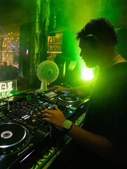 A clear view of my Pioneer DJ setup under green lighting. This is the industry standard equipment I use for all my gigs.