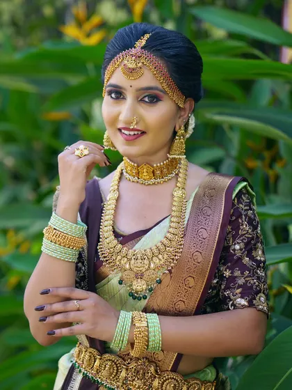 This bride's look is all about traditional elegance. The makeup is paired with a classic hair bun and heavy gold jewellery, perfect for a grand wedding ceremony.