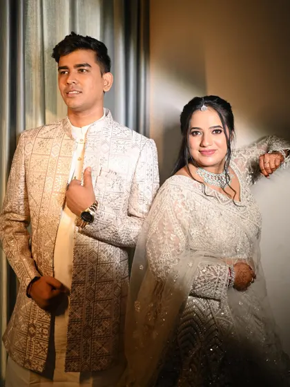 A stylish portrait of the couple. The bride's makeup is modern and chic, with a defined eye and glowing skin that complements her white lehenga.