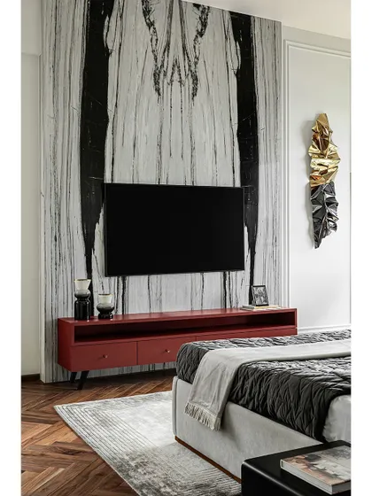 This shot highlights the dramatic book-matched marble panel behind the TV in the master bedroom. It serves as a stunning piece of natural art, creating a powerful focal point in the room.