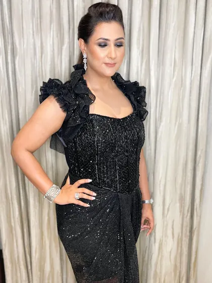 All about the drama. Her intense, glittery black smokey eyes are the star of the show, paired with a braided ponytail for a fierce and fashionable cocktail look.