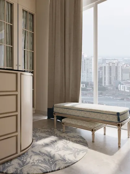 A custom upholstered bench provides a comfortable spot for getting ready, positioned to take advantage of the natural light from the large window.