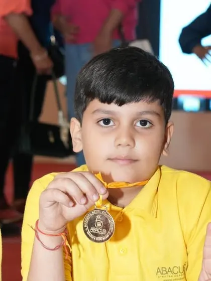 A close-up of a young champion proudly displaying his medal. This is a moment of pure joy and a memory he will cherish.