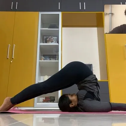 Join my advanced yoga classes online from anywhere in the world. In this virtual session, I am guiding a student through Halasana, or Plow Pose. My online classes provide the same level of detailed instruction and support as my in-person sessions, helping you progress in your practice from the comfort of your home.