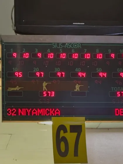 The electronic scoreboard displaying Niyamicka's impressive score of 573/600 in the 10m Air Pistol event. This is a testament to her precision and consistency under pressure.