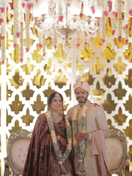 The stage for the wedding ceremony is just as important as the mandap. This setup features a gleaming gold lattice backdrop and traditional chairs, creating a regal setting for the couple.
