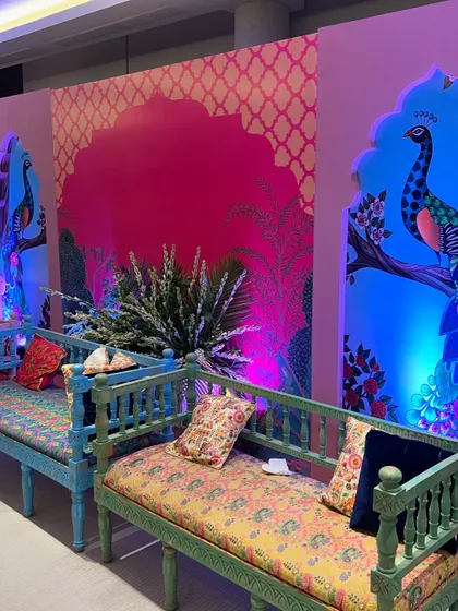 A closer look at the custom backdrops and colorful seating for the luxury Mehendi event, highlighting the hand-painted peacock details.