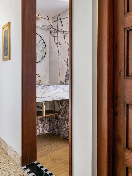A peek into the powder room of Apartment 5026, framed by a classic wooden door.