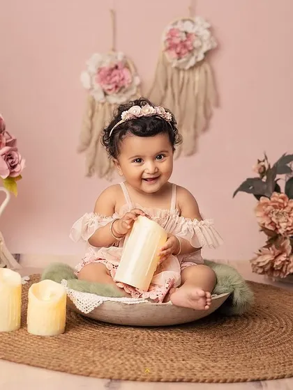 After the cake, we capture these sweet, simple moments. Here, she is sitting in a rustic bowl, surrounded by the soft, dreamy elements of her boho birthday setup.