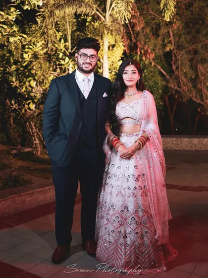 A classic outdoor portrait of a couple at their engagement, dressed in elegant evening wear.