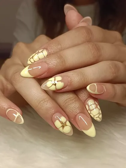 A full view of the butter yellow manicure with 3D flowers and croc-print art.