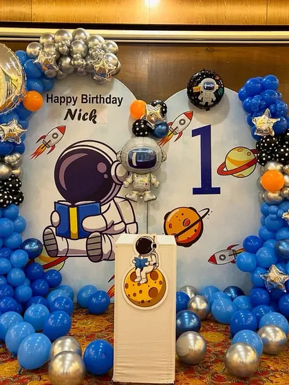 Another view of the space party decoration, showing the detailed balloon work and themed elements like planets and rockets on the backdrop.