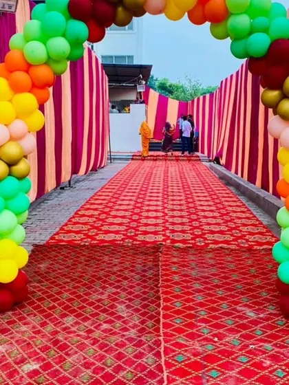 A grand entrance for a jungle-themed party. A colorful balloon arch leads guests down a red carpet, creating an exciting start to the celebration.