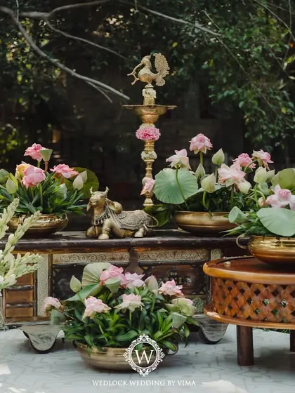 Details from a minimal and serene wedding setup. The decor features serene lotuses, traditional brass lamps, and other meaningful elements that reflect the couple's vision.