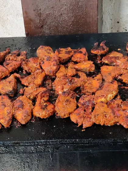 Freshly grilled fish tikka sizzling on the hot plate. We marinate our fish in a blend of spices before grilling it to perfection at our live counters.