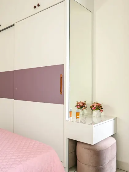 A serene bedroom with a minimal design. The soft pink and white color scheme, floral wallpaper, and butterfly-shaped hanging light create a gentle and whimsical atmosphere.