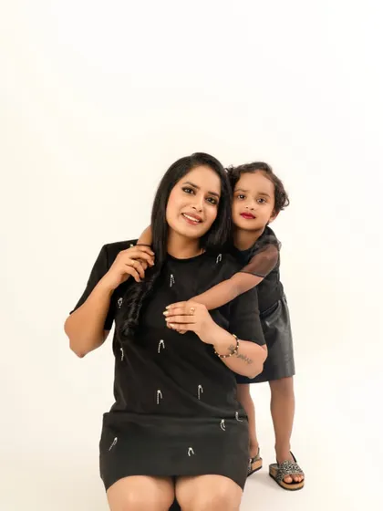 A sweet hug from behind. This studio portrait captures the loving and protective bond between a mother and her daughter in a simple and timeless style.