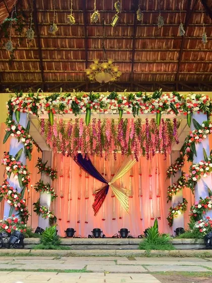A full view of an outdoor wedding stage with colorful draping and floral decor. We are experienced in setting up for events in resorts and open venues.