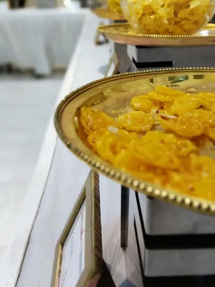 A close-up of our perfectly crafted jalebis, glistening on a golden tray. This traditional dessert is a sweet ending to a wonderful meal.