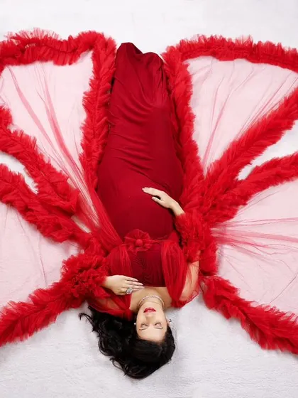 An artistic overhead shot. We love creating unique perspectives, like this one of our client lying down, her red gown spread out like butterfly wings.