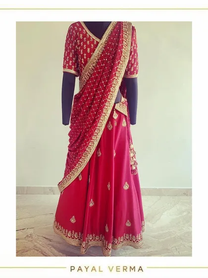 A studio view of a bespoke oxblood lehenga. This piece features intricate dabka hand-embroidery and is paired with a delicate mukaish work dupatta.
