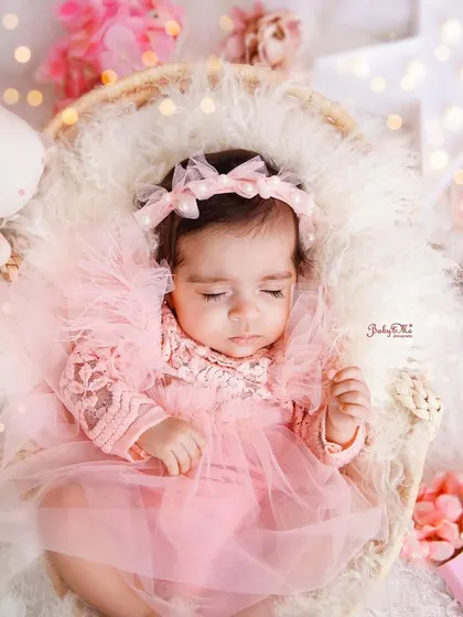 Dressed in a delicate pink tulle dress, this little princess is sleeping peacefully. The soft lighting and dreamy props create a truly magical atmosphere.