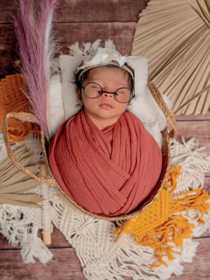 A wise little soul. I love the contrast of the rustic, boho props with the intellectual touch of the tiny glasses in this creative newborn portrait.