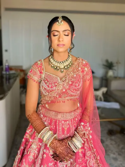 A serene moment showing the complete bridal look. The floral bun adds a fresh and natural element to her traditional attire.