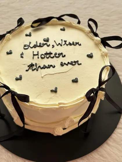 A close-up of the chic black and white cake with ribbon details.