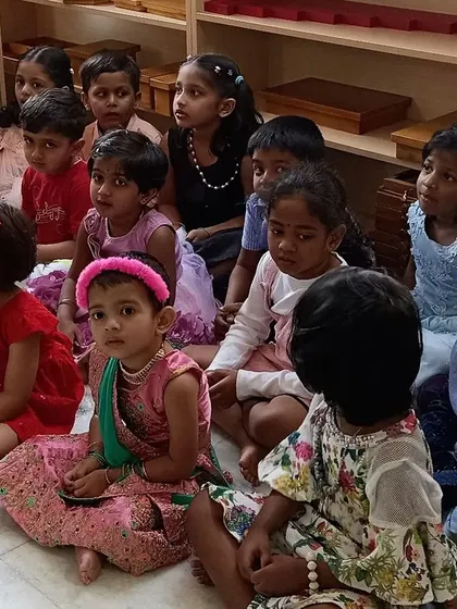 An attentive audience of children watching their friends perform during Talent Day. It's a day for celebrating each child's unique abilities, whether it's singing, dancing, or telling jokes.