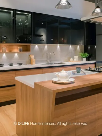 This modern kitchen features a large island with a breakfast bar, sleek black and wood cabinets, and state-of-the-art appliances. It's a perfect space for both cooking and socializing.