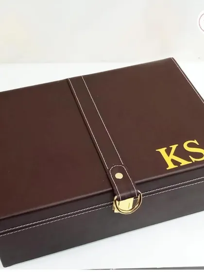 The exterior of the handsome, personalized groomsman box, featuring the recipient's initials in gold.