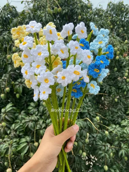 A mixed bouquet of white, yellow, and blue forget-me-nots.