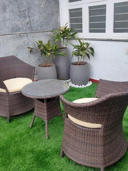 Create a perfect spot for your morning coffee. We combined soft artificial turf with stylish wicker furniture and a few carefully placed plants to make this small patio a comfortable and inviting outdoor lounge.